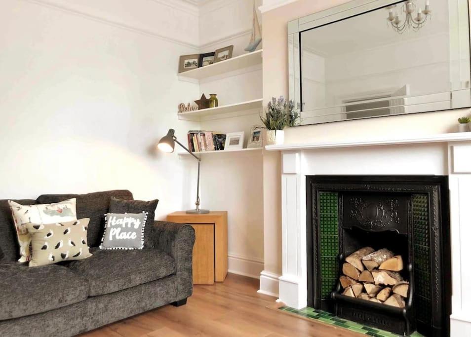 a living room with a couch and a fireplace at Sunny Seaside Beach House Lytham Centre sleeps 8 in Lytham St Annes