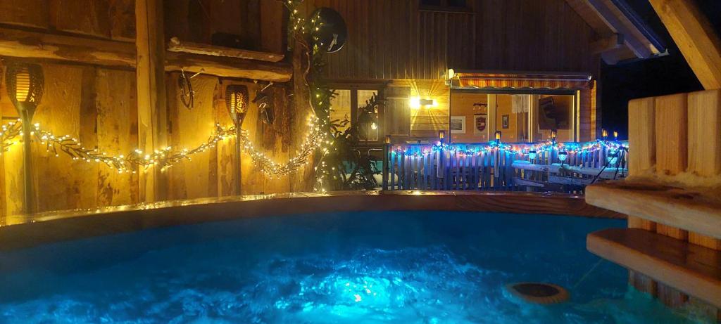 a swimming pool with christmas lights in a room at Chalet Die Berghexn in Klippitztorl