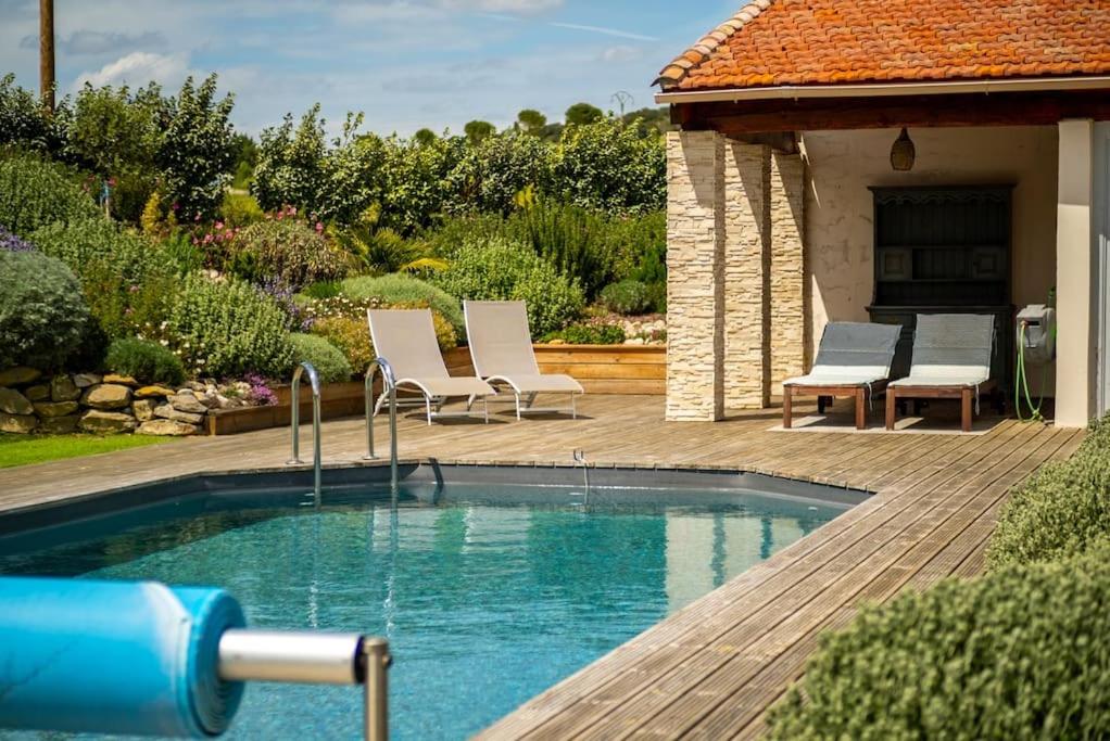 una piscina en un patio con 2 sillas y una casa en Gîte Vent Autan - Holiday Home Vent Autan, en Limoux