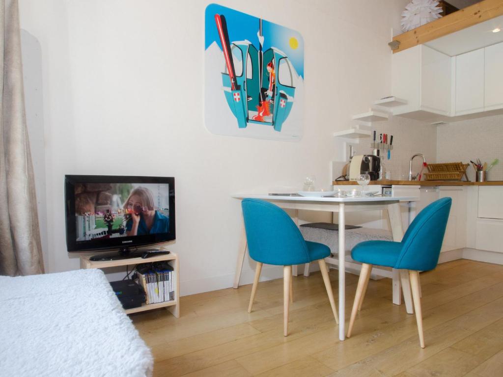 salon ze stołem, krzesłami i telewizorem w obiekcie Appartement cosy avec balcon et WiFi à Chamonix - FR-1-343-203 w Chamonix-Mont-Blanc