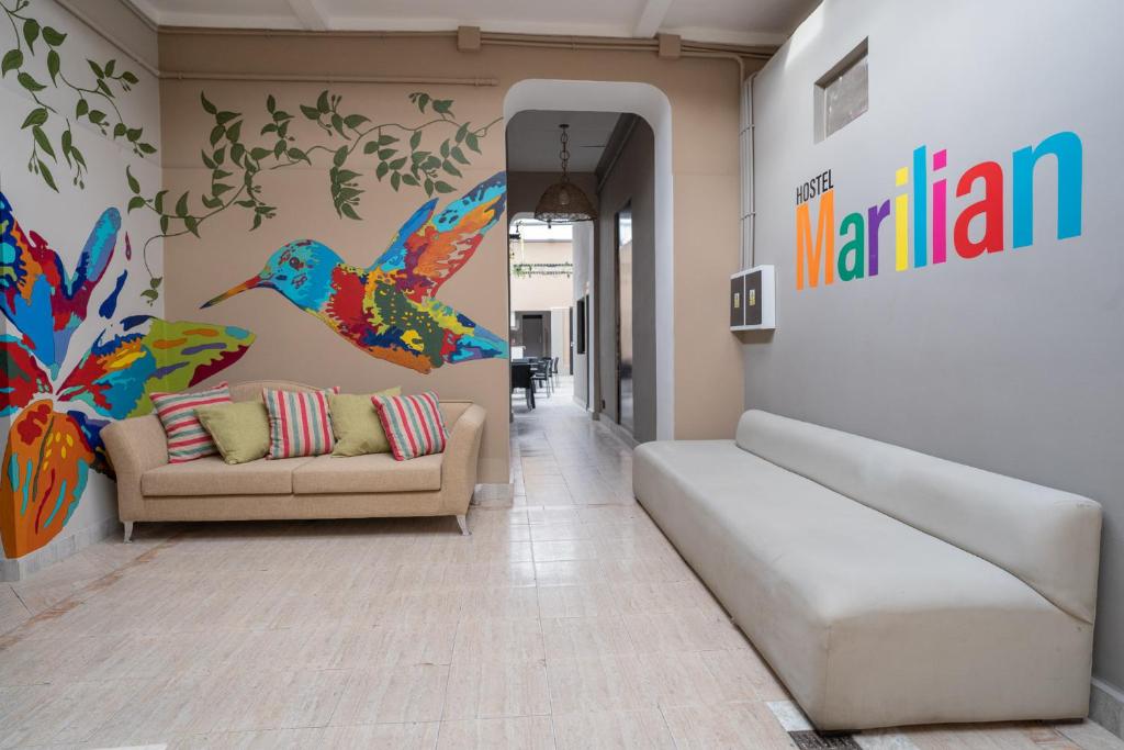 una sala de estar con sofá y un pájaro en la pared en Hostel Marilian en Salta