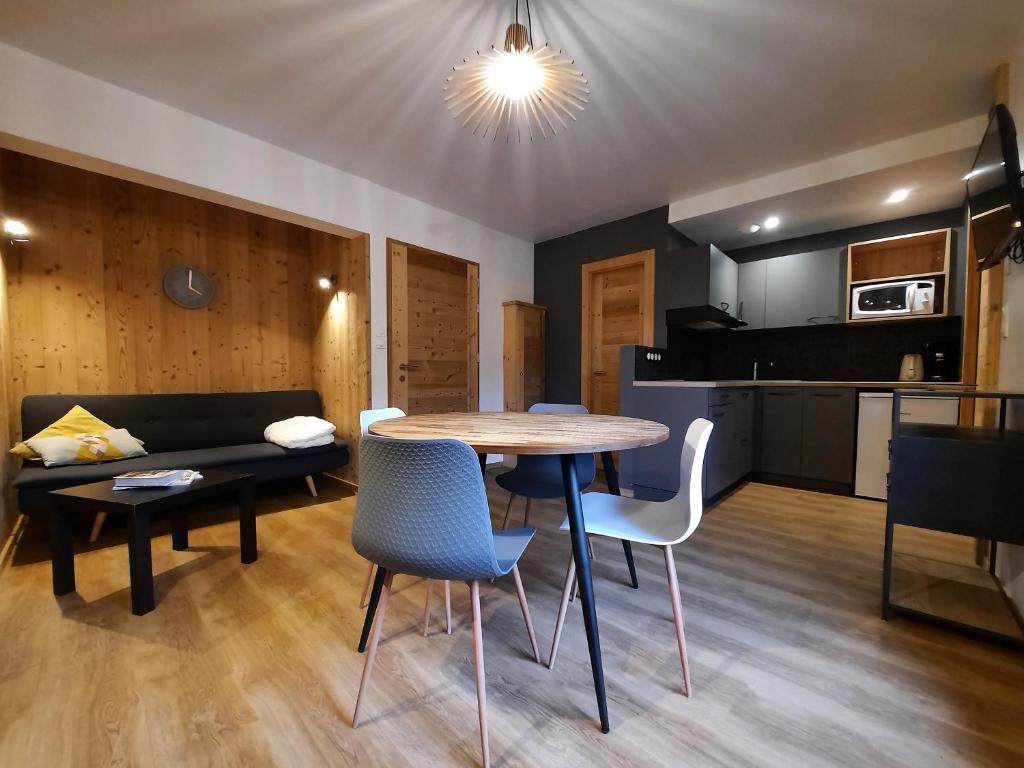 een woonkamer met een tafel en stoelen en een bank bij Appartement Les 3 cols Morzine, 2 pièces, 2 personnes in Morzine