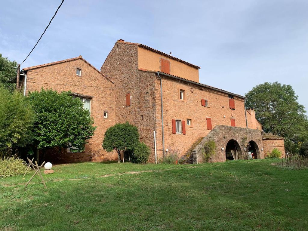 un gran edificio de ladrillo en un campo de césped en La Boriette du Rougier, en Montlaur