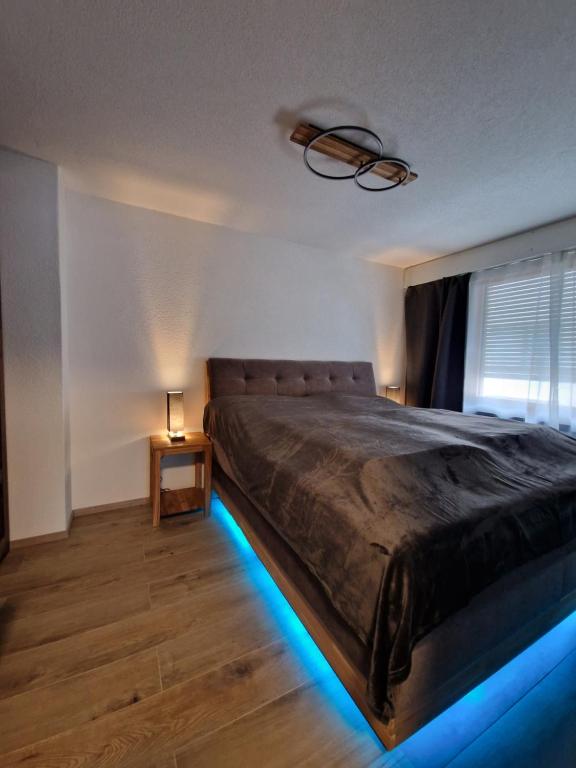 1 dormitorio con 1 cama con luces de LED azules en FeWo's und Apartment's Schöneck en Davos