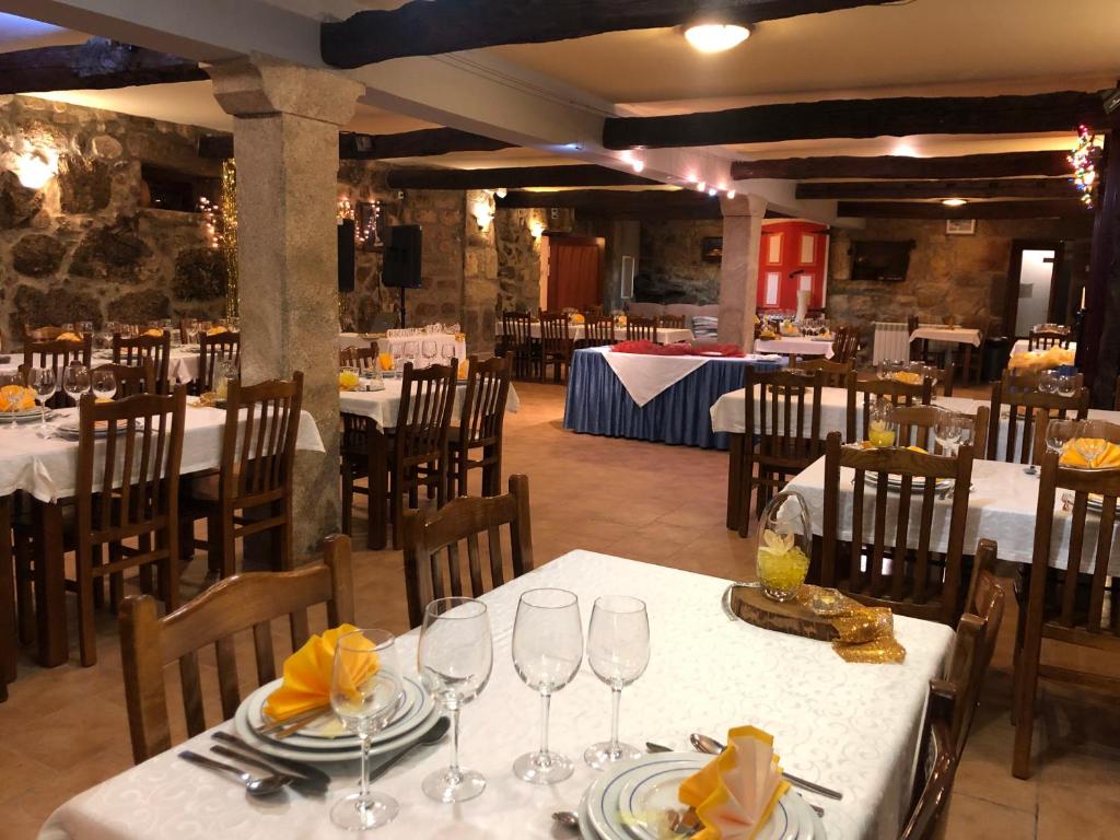 uma sala de jantar com mesas e cadeiras com roupa de mesa branca em Quinta das Cegonhas em Gouveia