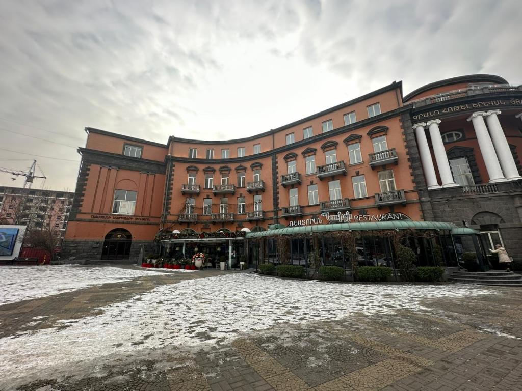 a large building with snow on the ground in front of it at Alex in Yerevan