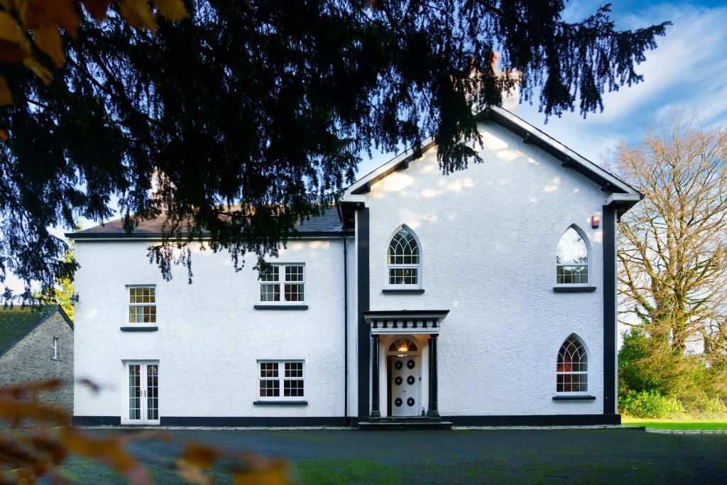 een groot wit huis met een grote deur bij Ty Bledrws - family retreat near the Cardigan Bay coast 