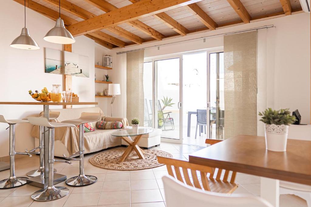 a kitchen and living room with a table and chairs at Casa Luz in Fuzeta