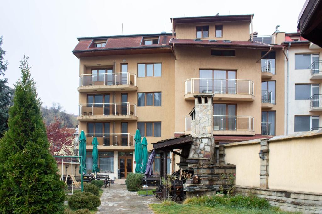 a large apartment building with a fire hydrant in front of it at Meteor Family Hotel in Chepelare