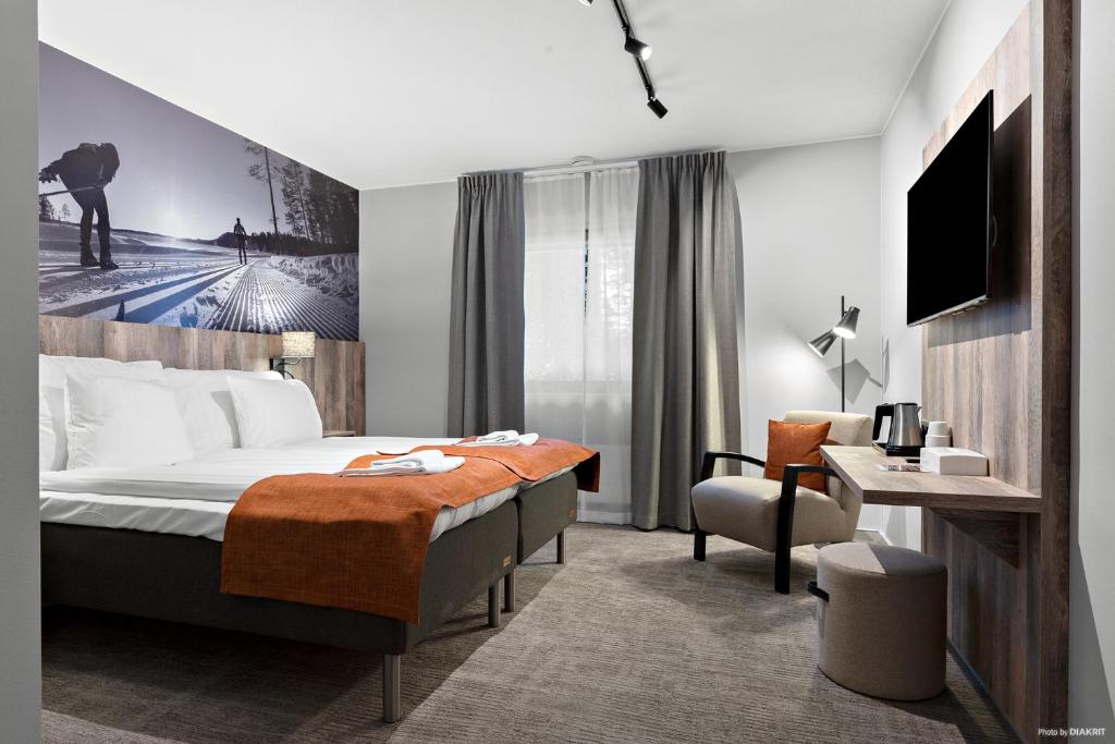 una camera d'albergo con letto e scrivania di First Camp Moraparken Hotel a Mora