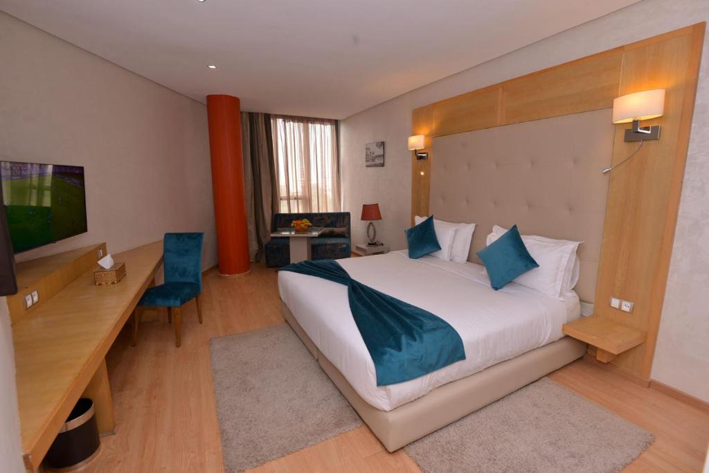 een hotelkamer met een groot bed en een bureau bij Le 135 appart hotel in Casablanca