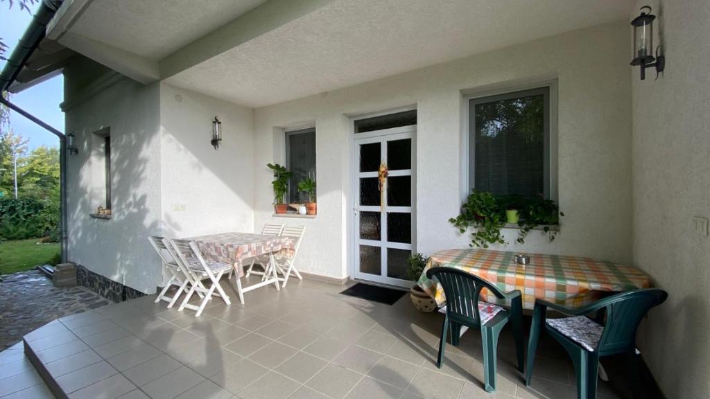 un patio con mesa y sillas en un porche en Pipacs apartmanok, en Balatonboglár