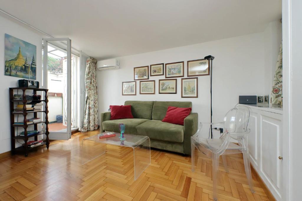 ローマにあるLovely Apartment Via Sistinaのリビングルーム(緑のソファ、ガラスのテーブル付)
