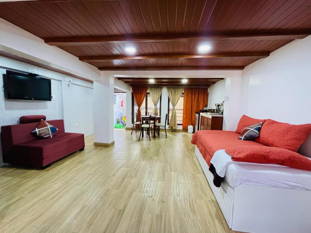 sala de estar amplia con sofá y TV en Hermoso apartamento en Baños de Agua Santa, en Baños