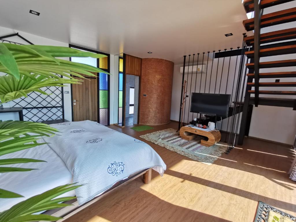 a bedroom with a bed and a tv in it at Oxy Resort in Ban Mai Phatthana