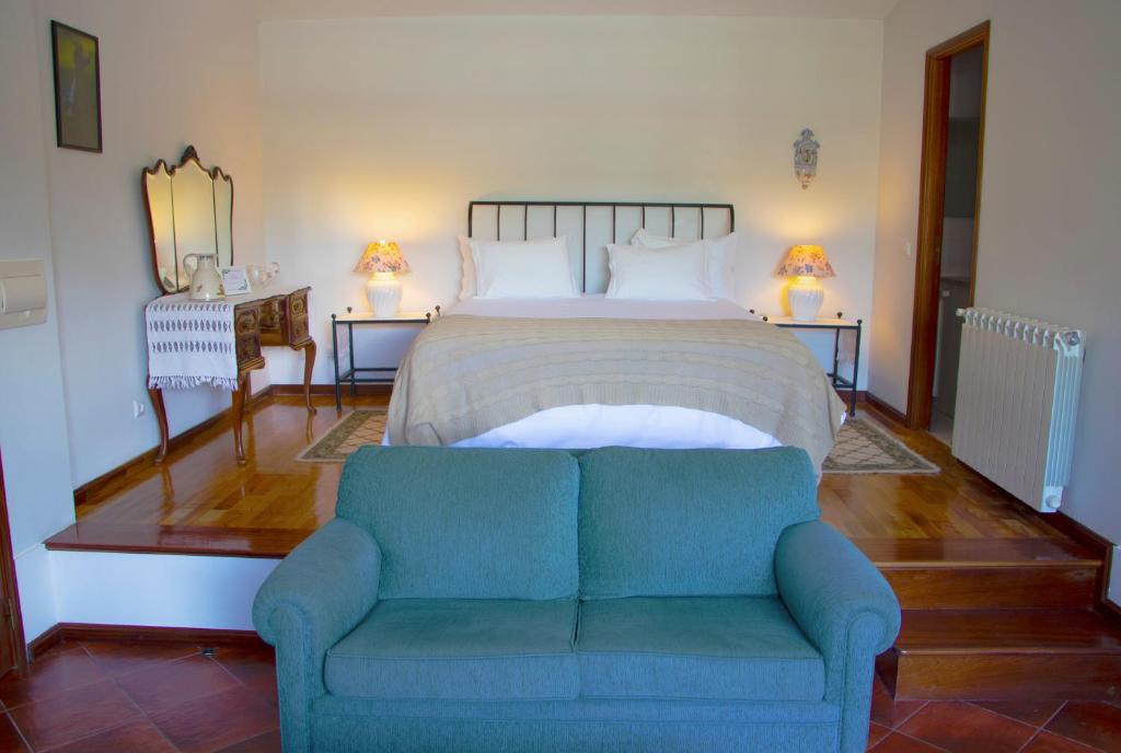 Un dormitorio con una cama con un sofá azul. en Casa da Reina, en Viana do Castelo