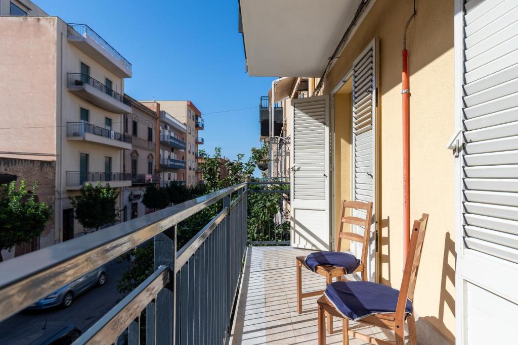 2 sedie sedute sul balcone di un edificio di Solemar Sicilia - Casa Butera a Bagheria