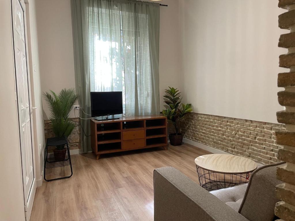 a living room with a tv on a wooden dresser at ak apartments in Athens