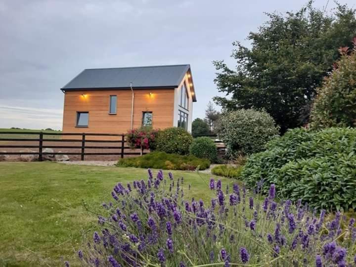a house with purple flowers in front of a yard at Home Close to Center Parcs Longford 
