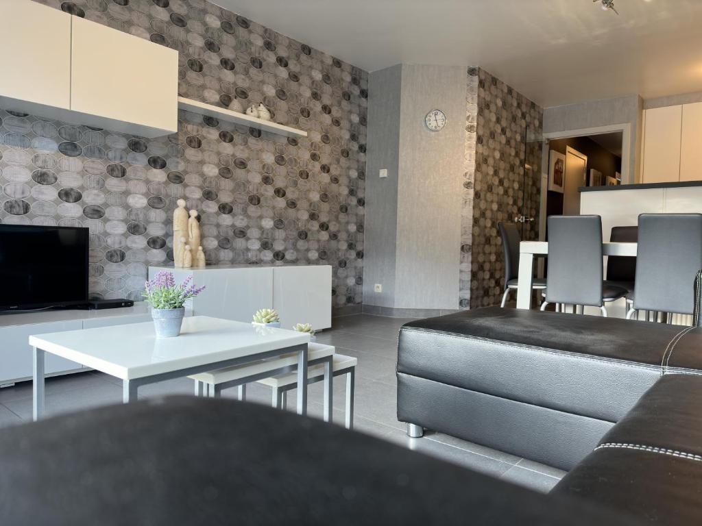 uma sala de estar com uma mesa e uma cozinha em Sea Horse 0401 em Nieuwpoort
