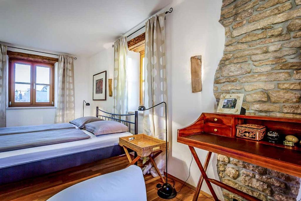 sypialnia z łóżkiem i kamienną ścianą w obiekcie Villa Perla Sisan w mieście Šišan