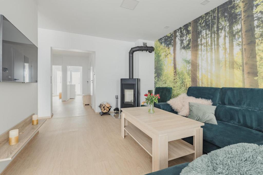 a living room with a blue couch and a table at Sun&Sport Apartament MAJA z ogródkiem in Szczyrk