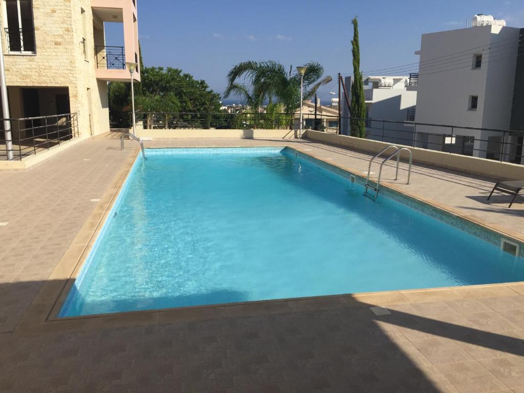 a large blue swimming pool in front of a building at Mazotos Panoramic Village in Mazotos