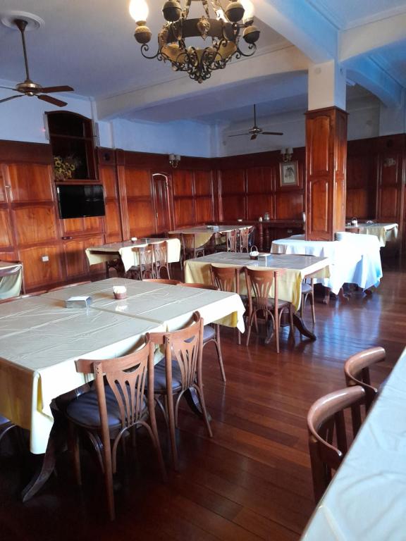 a dining room with tables and chairs and a chandelier at HOTEL PORTAL DE SALTA in Salta