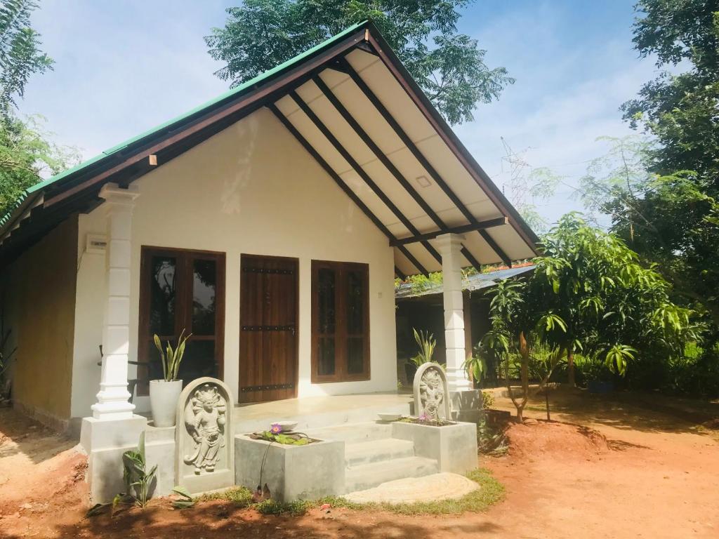 ein kleines weißes Haus mit einer Veranda in der Unterkunft The wild culture in Sigiriya