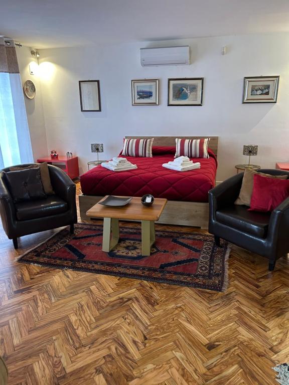 een woonkamer met een bed en 2 stoelen bij Piccola Suite in Castiglione del Lago