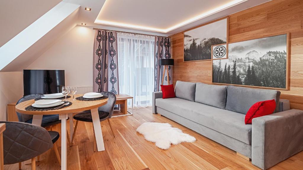 a living room with a couch and a table at Resorts J Białka Tatrzańska z sauną, Sun & Snow in Białka Tatrzanska