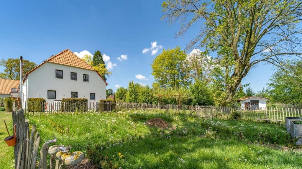 a white house with a fence in a yard at Ferienwohnung Die Idyllische mit Sauna in Kleve