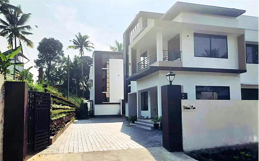 a white house with a gate in front of it at Urbane Cove in Trivandrum