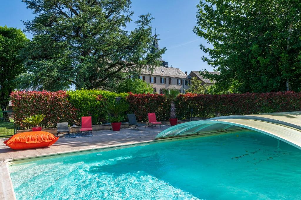 a swimming pool with chairs and a house at Le Clos d'Albray - Chambres d'hôtes et gite in Comps-la-Grand-Ville