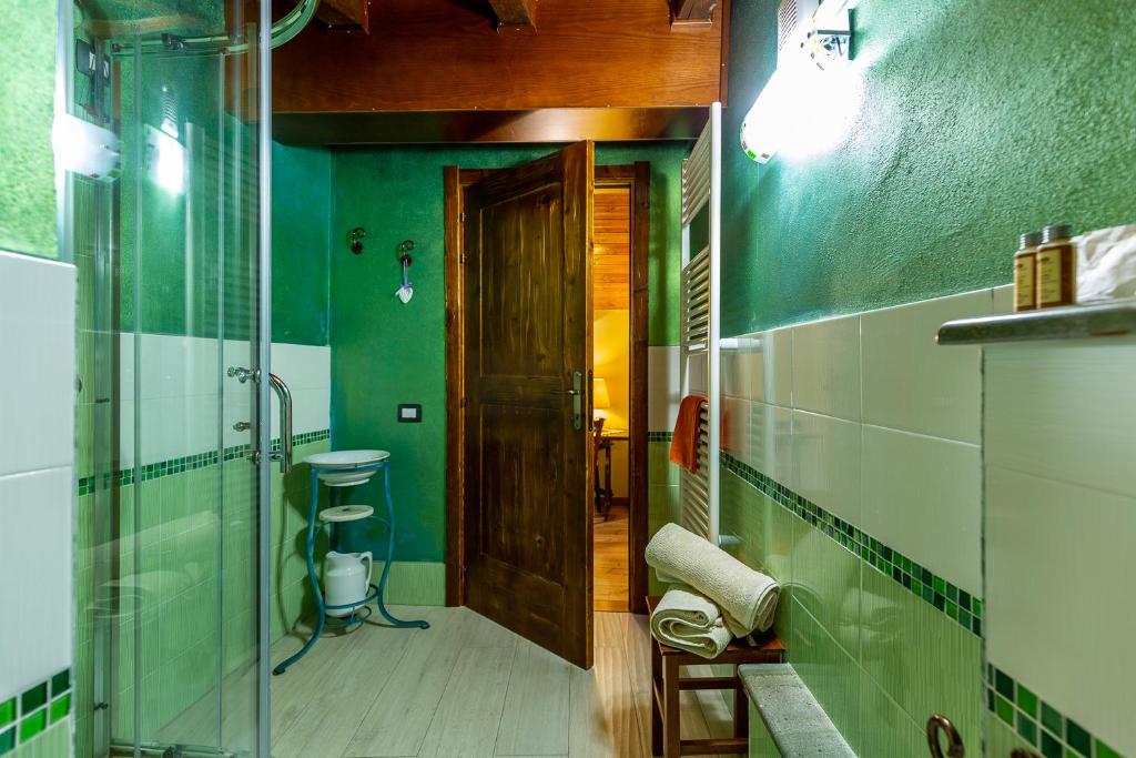 bagno con doccia e porta in vetro di Affittacamere Is Coronas a Ìsili