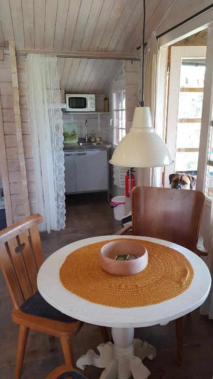 una cocina con mesa y un perro en una habitación en Tofvehults Boende en Skaftet