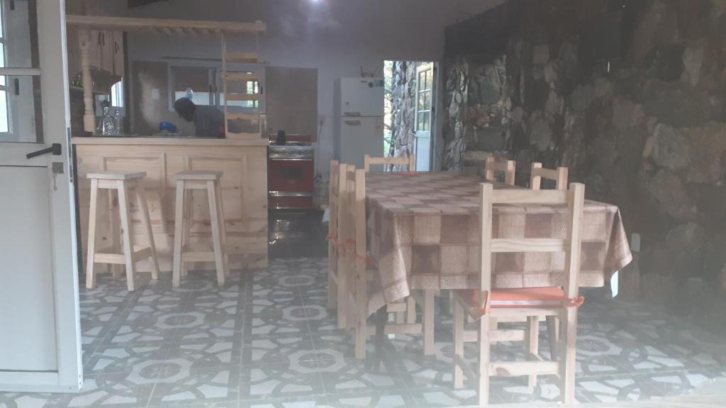a kitchen with a table and chairs in a room at Cabaña pared de piedra in Carpintería