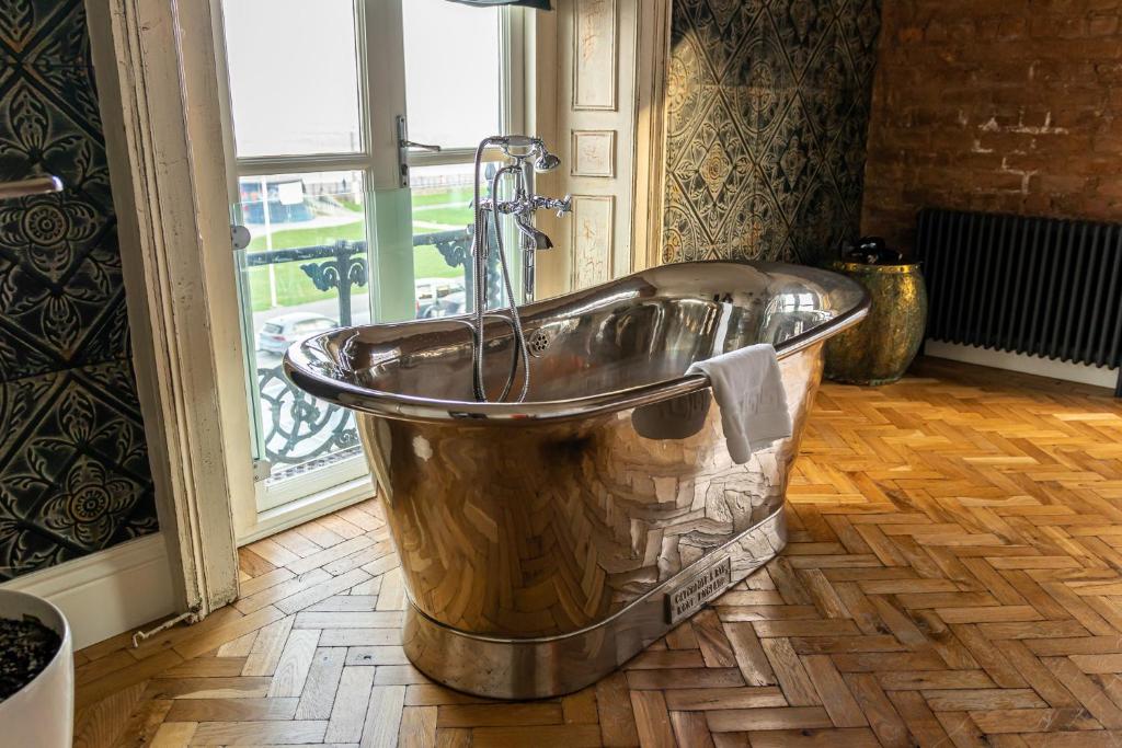 una vasca in metallo in un bagno con finestra di The Palm a Bray