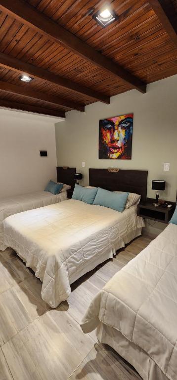 a bedroom with two beds and a painting on the wall at Nomades Apartamentos in Paso de los Libres