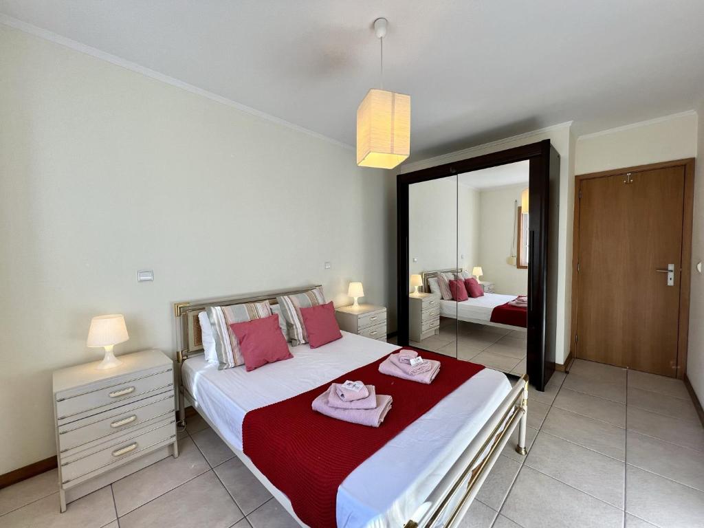 a bedroom with a large bed and a mirror at Albufeira Brightness by Homing in Albufeira