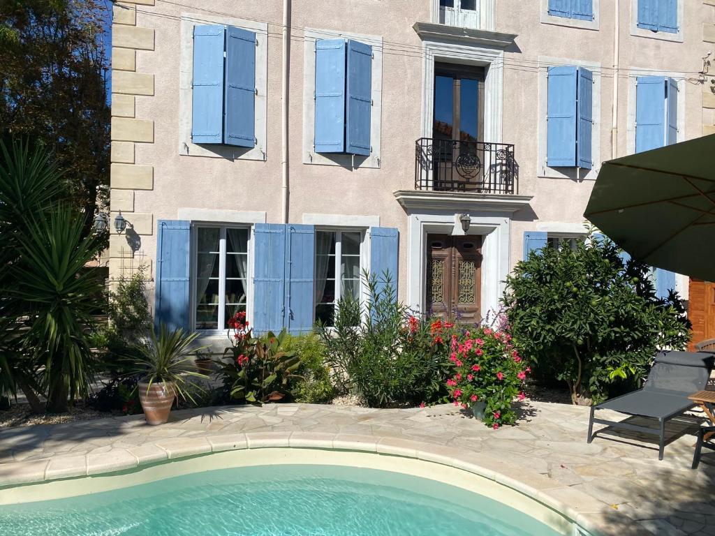 una casa con piscina frente a un edificio en Maison du Midi, 2 Gîtes de charme en Ginestas