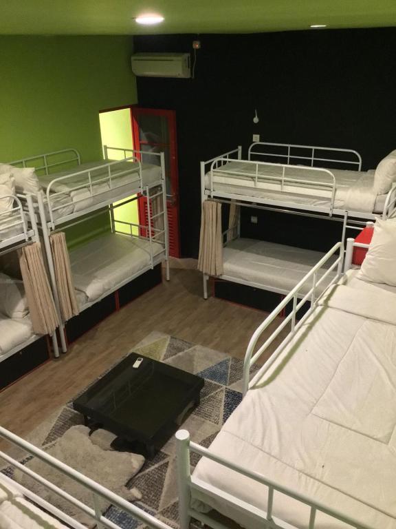 a room with three bunk beds and a rug at Bandung Hostel in Bandung