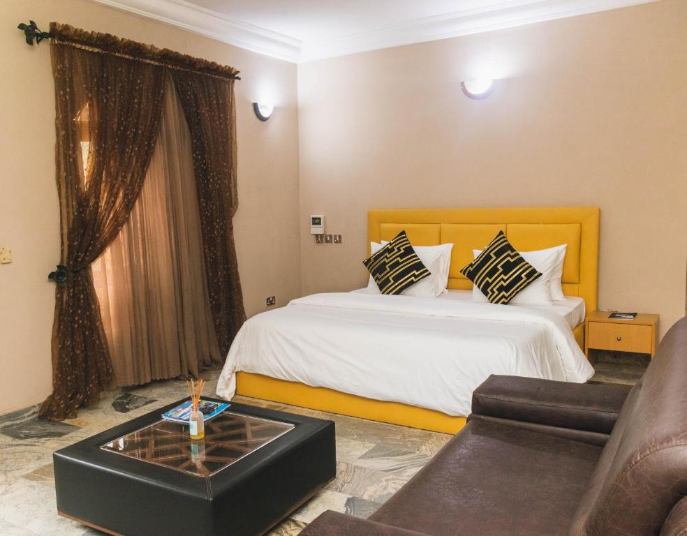 um quarto de hotel com uma cama e um sofá em J's Place em Abuja