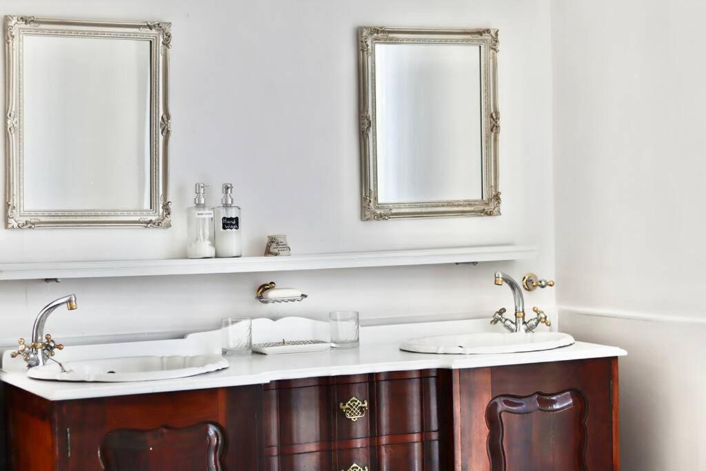 uma casa de banho com dois lavatórios e dois espelhos em Eucalyptus Cottage na Cidade do Cabo