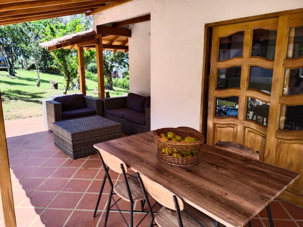 uma mesa de madeira com uma cesta de frutas num pátio em Hermosa casa para vacaciones en San José de Suaita em San José de Suaita