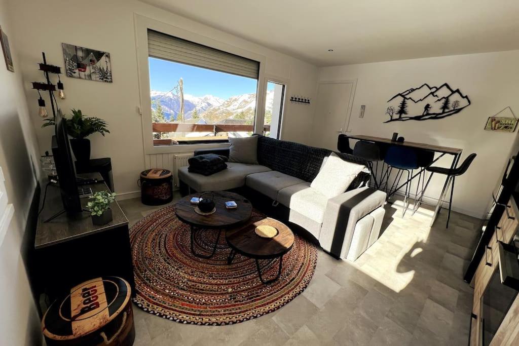 a living room with a couch and a table at Appartement cocooning 2 chambres in Gourette