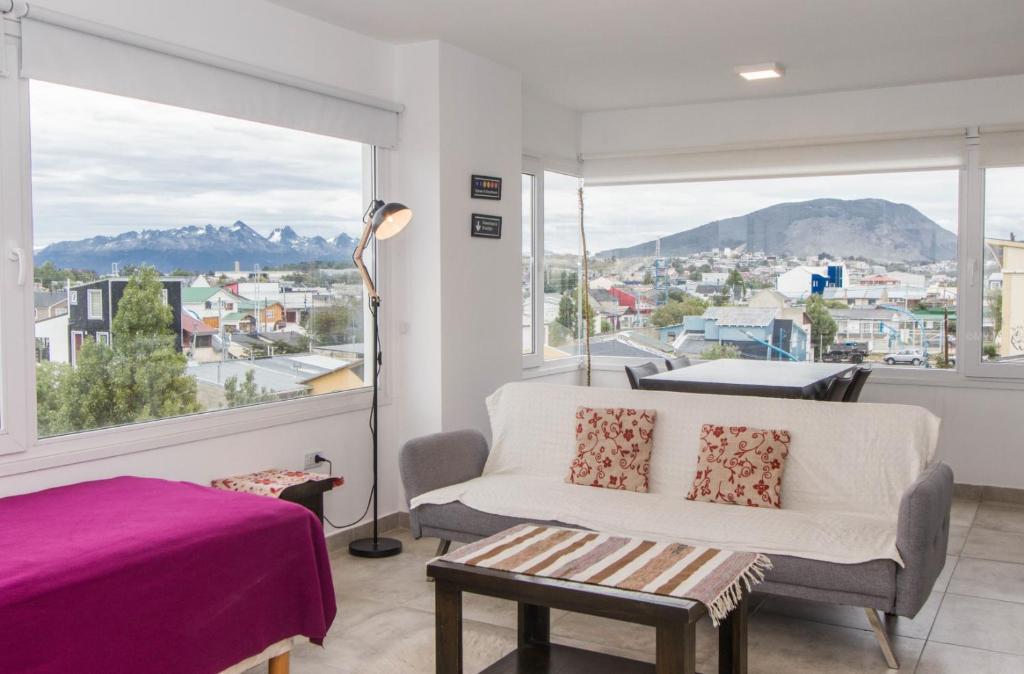 sala de estar con sofá y ventana grande en Walanika Apartamentos en Ushuaia