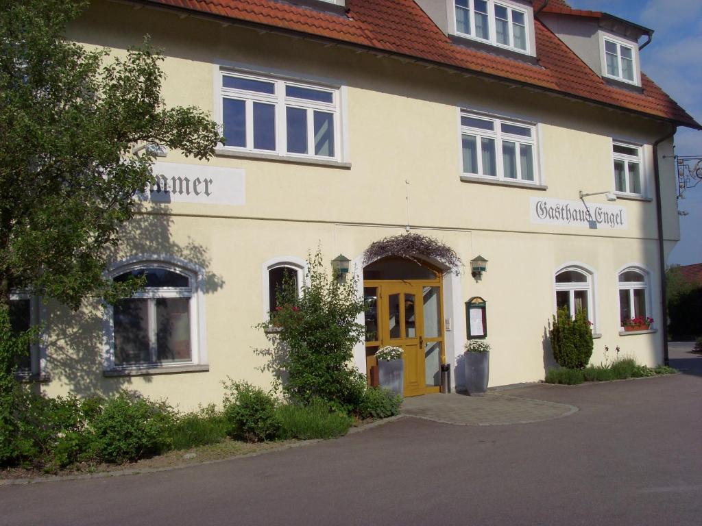 
a white building with a blue door and windows at Hotel & Restaurant Engel in Herbertingen

