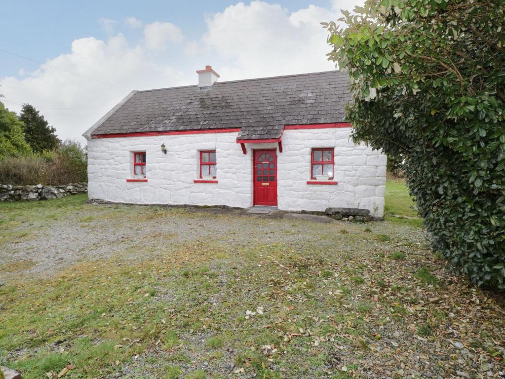a small white house with a red door at Ti Sonny in Glinsk