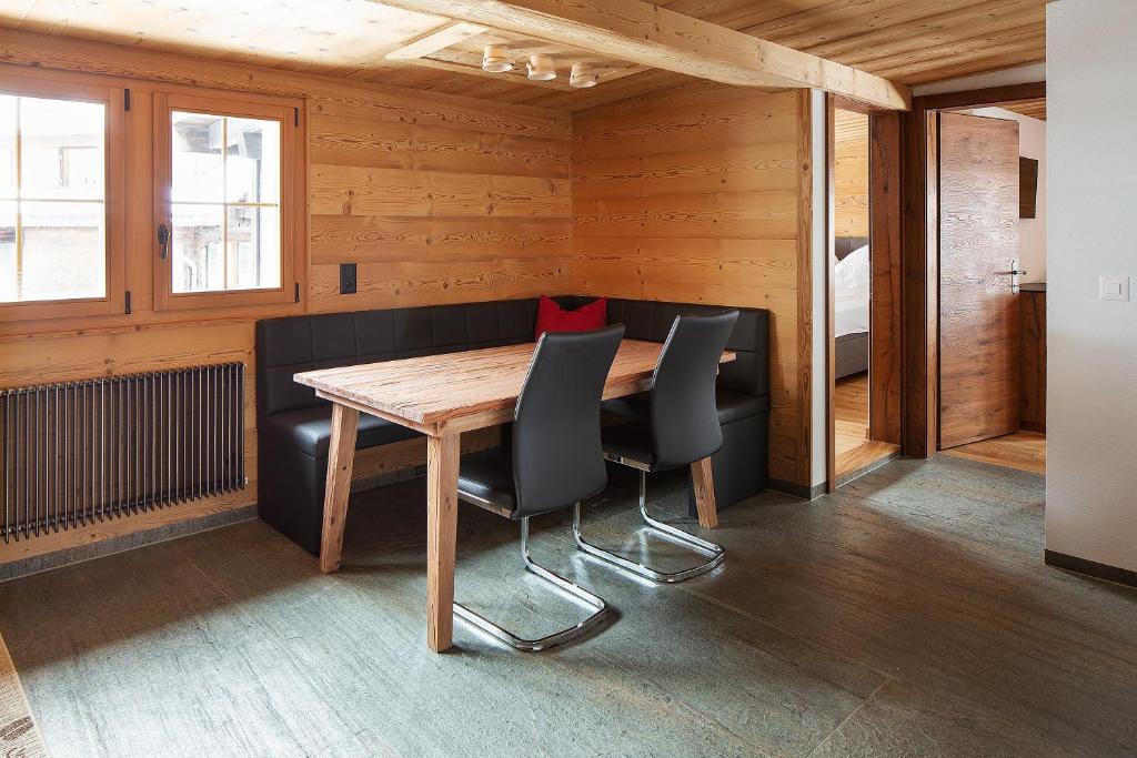a dining room with a wooden table and black chairs at Chalet Swiss Alps in Grindelwald